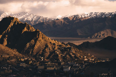 Panoramic view of townscape by mountains against sky