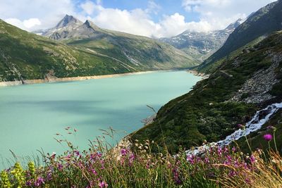 Scenic view of lake by mountains against sky