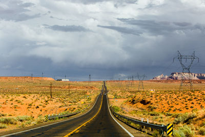 Road amidst field against sky