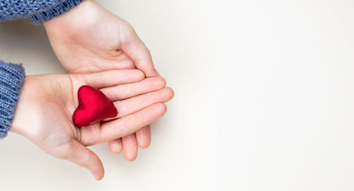 Close-up of woman holding hands over white background