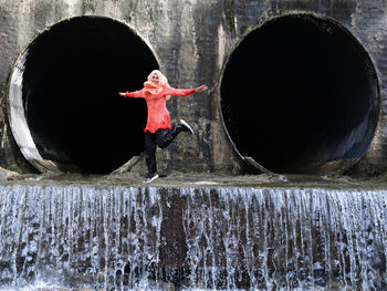 Rear view of woman standing by fountain