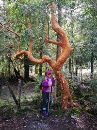 Man standing by sculpture in forest