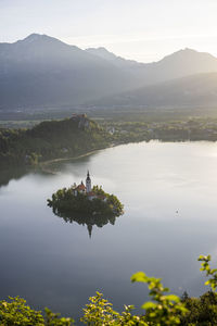 Scenic view of lake by mountains against sky