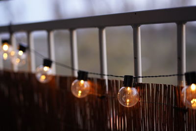 Low angle view of illuminated light bulbs hanging