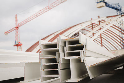 I-beam steel painted white lay piles on concrete, raw materials used in building construction.