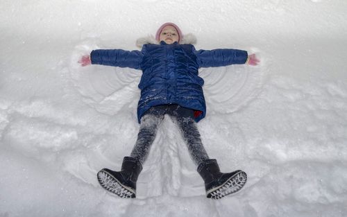 High angle portrait of girl making snow angel