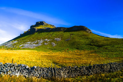 Scenic view of mountain against blue sky