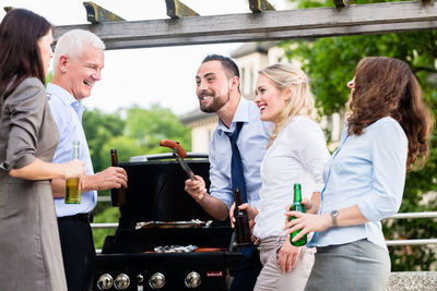 Happy colleagues with food and drinks enjoying during party