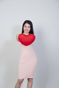 Portrait of a smiling young woman against white background