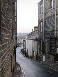 Road amidst buildings in city against sky