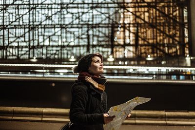 Full length of woman holding umbrella in city