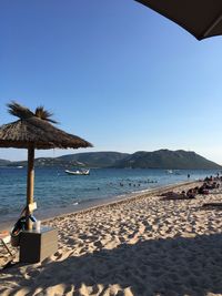 Scenic view of beach against clear blue sky