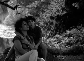 Portrait of mother and son sitting in forest