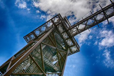 Low angle view of metallic structure against blue sky