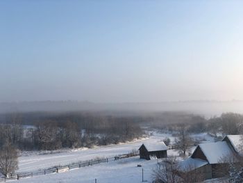 Snow covered houses against sky during winter