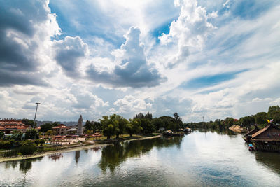 Scenic view of river by city against sky