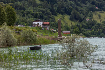 Scenic view of river amidst trees and house in forest