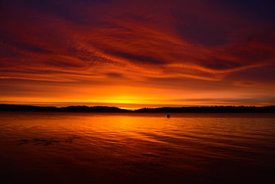 Scenic view of sea against dramatic sky during sunset