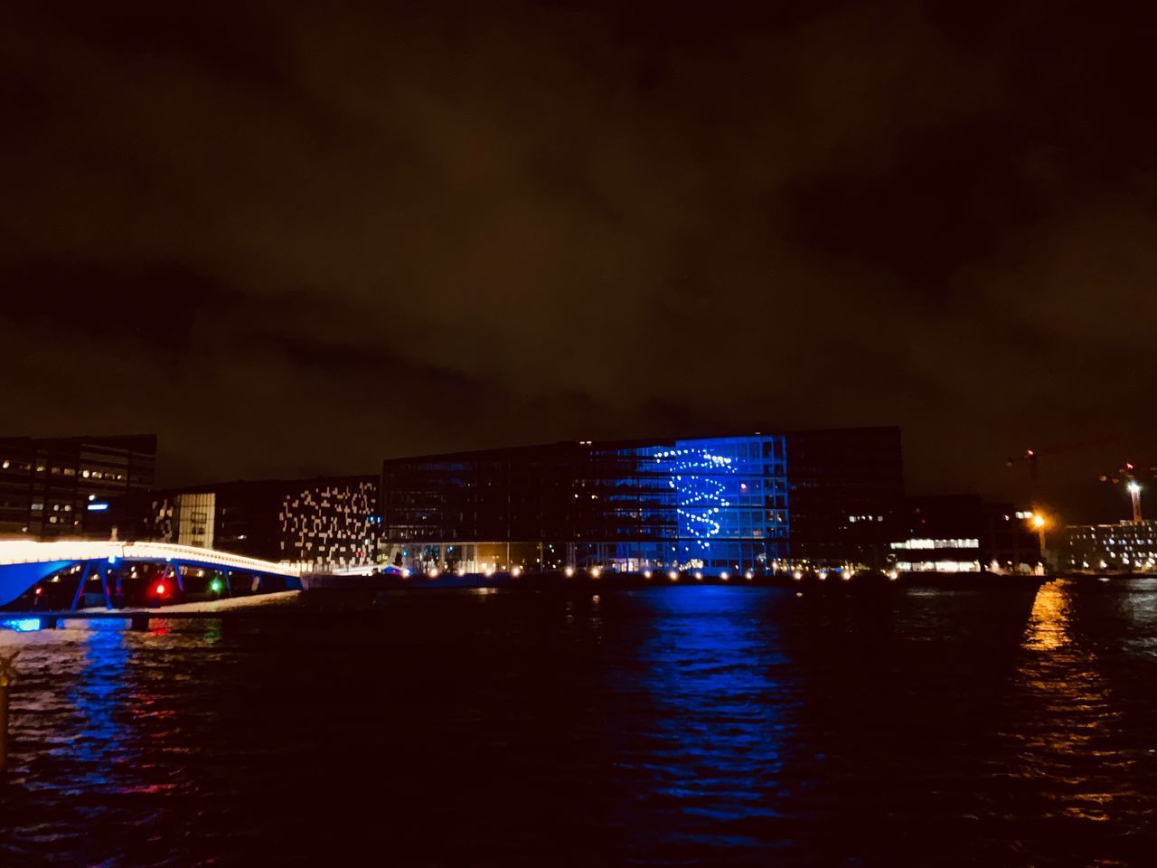 ILLUMINATED BUILDINGS BY SEA AT NIGHT