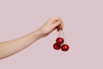 Cropped hand of woman playing guitar against white background