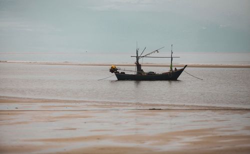 Fishing boat in sea against sky