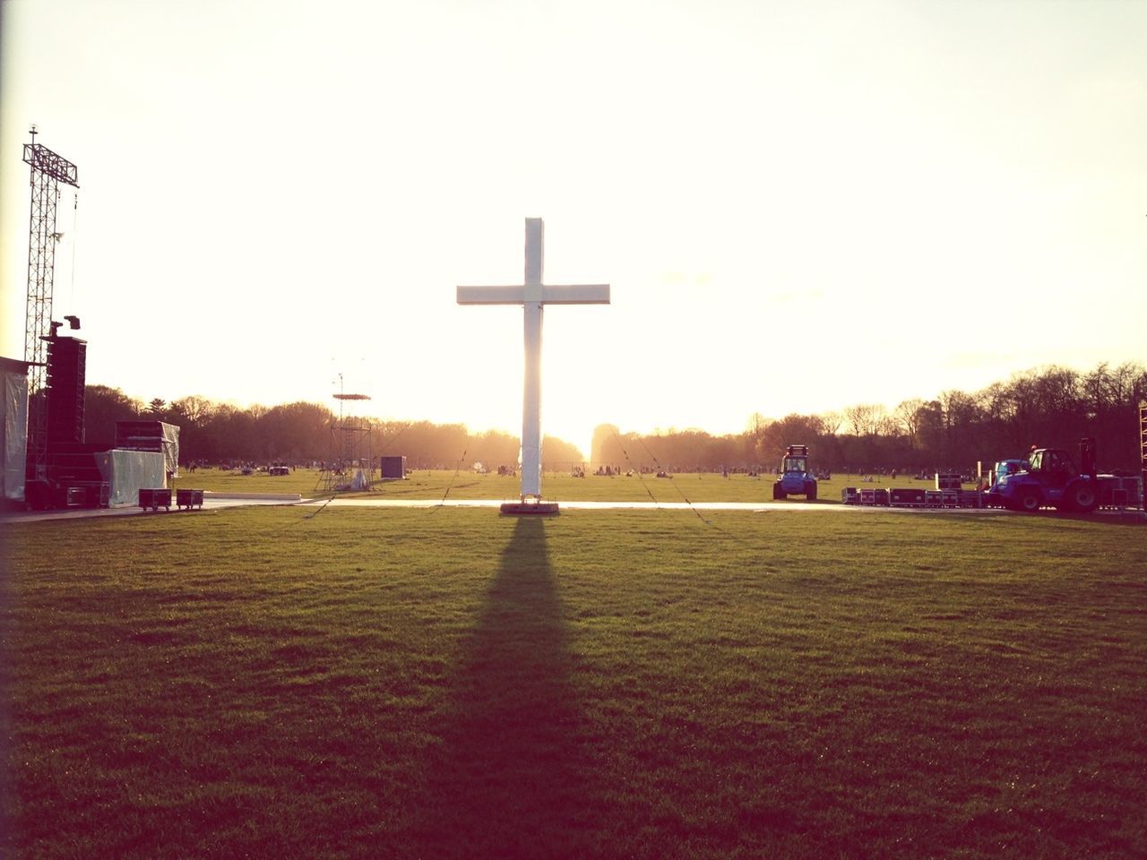 clear sky, tree, grass, sunset, sun, sunlight, street light, built structure, sky, building exterior, copy space, architecture, field, tranquility, nature, outdoors, park - man made space, incidental people, transportation, silhouette