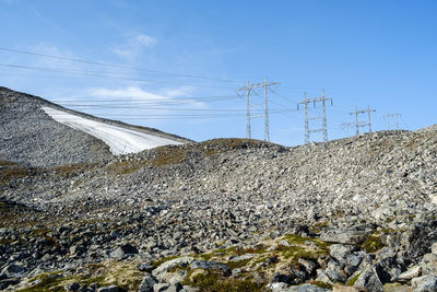 Low angle view of electricity pylon against sky