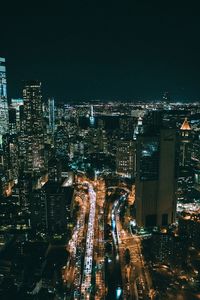 Illuminated cityscape against sky at night