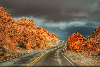 Road amidst trees against sky during autumn