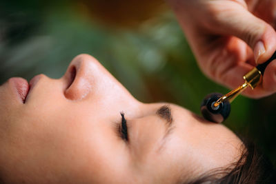 Face roller. woman massaging face with roller at home.