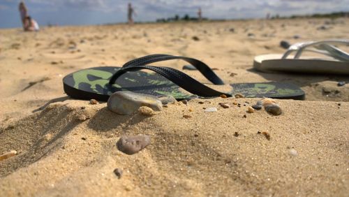 Close-up of shoes on sand