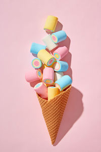 Close-up of multi colored heart shape on pink background