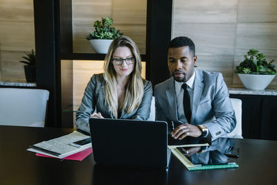 Business colleagues working on laptop computer in office