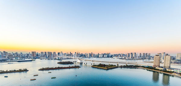 View of city buildings against sky during sunset