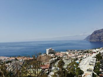 High angle view of townscape by sea against sky