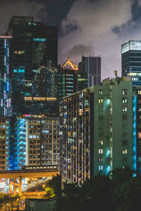 Illuminated buildings in city against sky at night