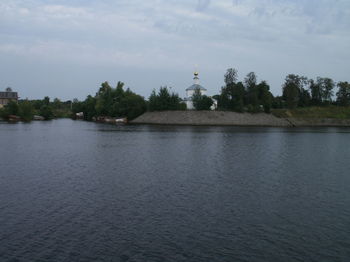 Scenic view of river against cloudy sky