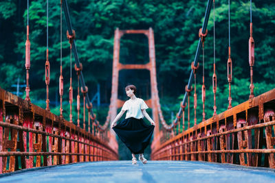 Portrait of young woman standing on bridge