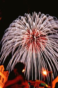 Low angle view of illuminated fireworks against sky at night