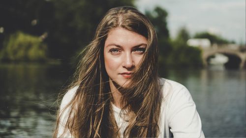 Portrait of young woman against lake