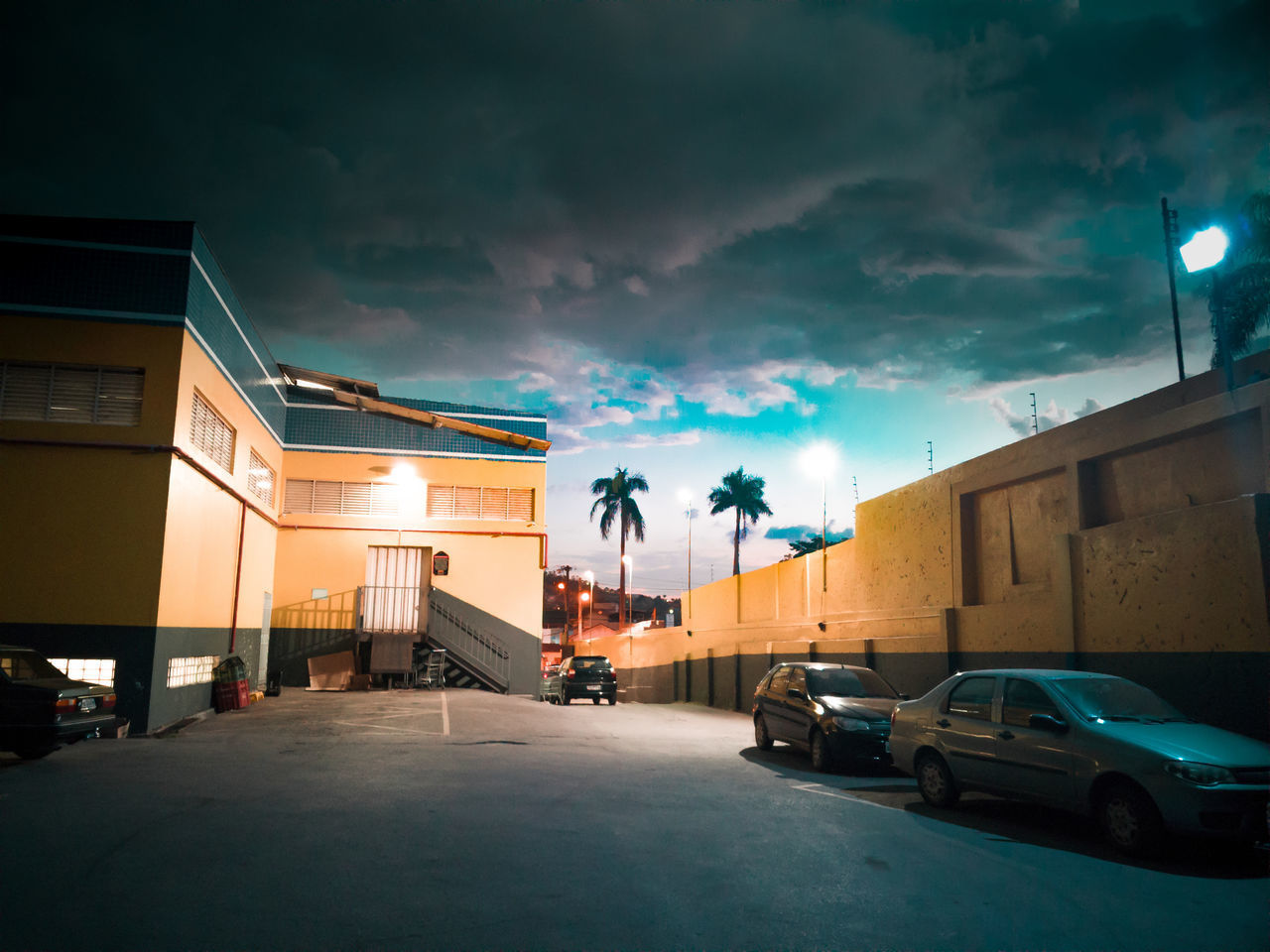 CARS ON STREET AGAINST ILLUMINATED BUILDINGS IN CITY AT NIGHT