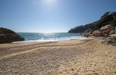 Scenic view of beach against clear blue sky