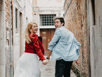 Happy young couple standing on the wall