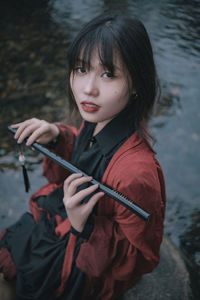 Portrait of young woman holding cigarette