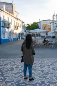 Rear view of woman walking on street in city