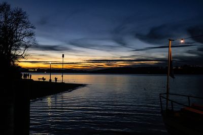 Silhouette pier on lake against sky at sunset