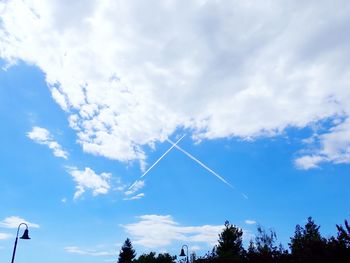 Low angle view of vapor trail against blue sky