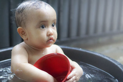 Close-up of cute baby bathing in tub