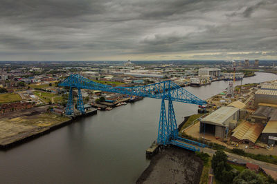 High angle view of buildings by river against sky