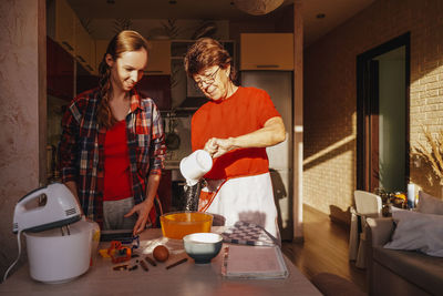 Mother and daughter preparing food at home